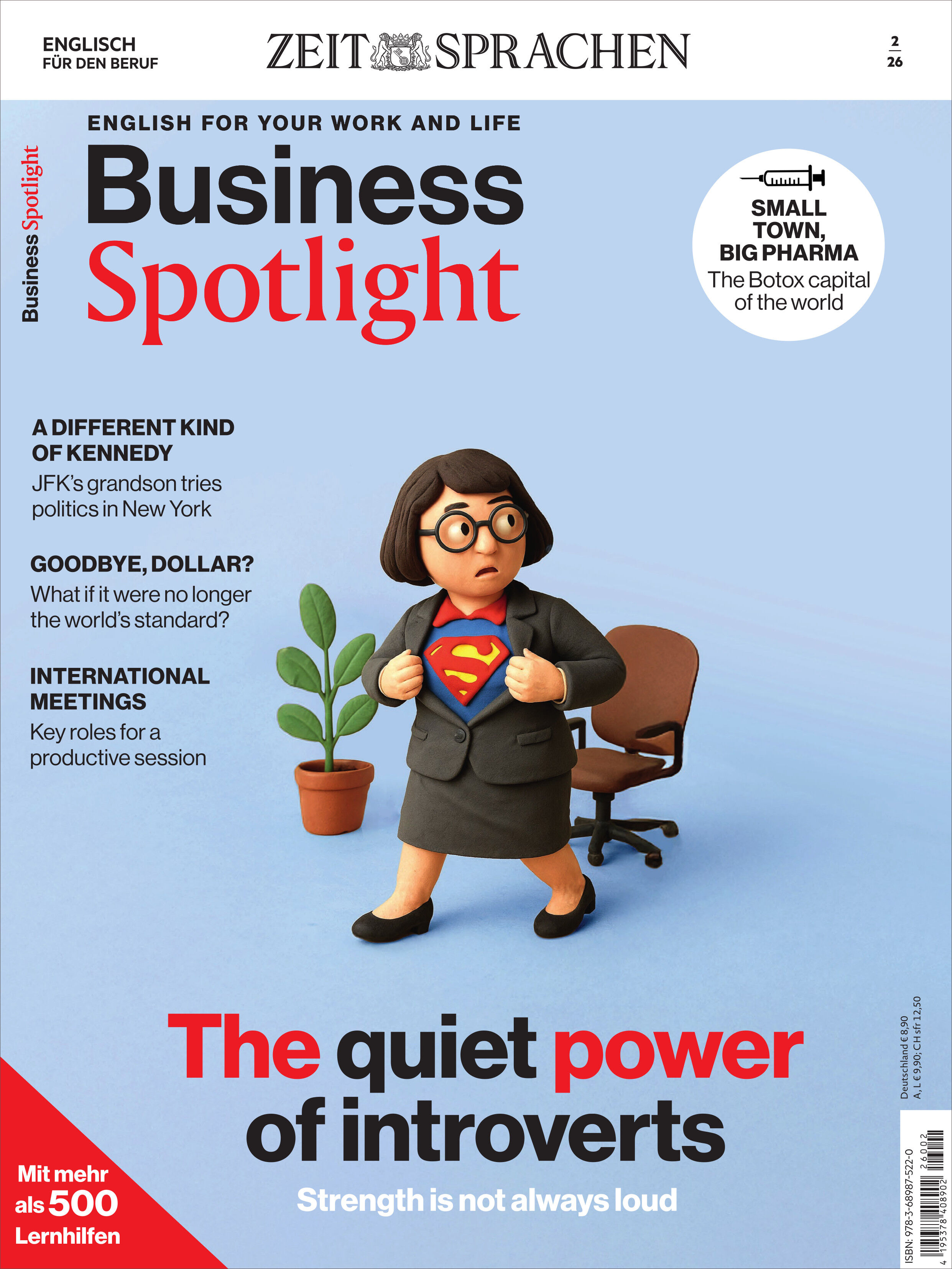 Auf dem Cover des Business Spotlight Magazins steht eine animierte Figur im Business-Outfit, die ein Superman-T-Shirt unter ihrem Blazer zeigt. Im Hintergrund ist eine Topfpflanze. Überschriften und Titel mit Themen zu Business Englisch und Introvertierten heben sich auf hellblauem Hintergrund ab.