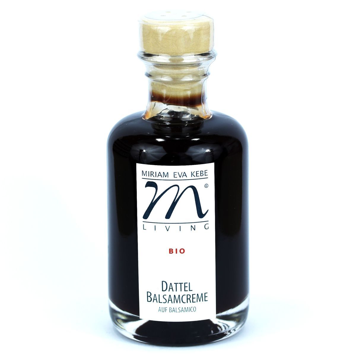 Das Bild zeigt eine elegante Glasflasche mit Korkverschluss, gefüllt mit dunkelbrauner Dattel Balsamcreme aus biologischem Anbau. Das weiße Etikett trägt die Marke „Kebe Living“, Produktnamen und Hinweise auf Bio-Qualität. Die Flasche steht vor weißem Hintergrund.