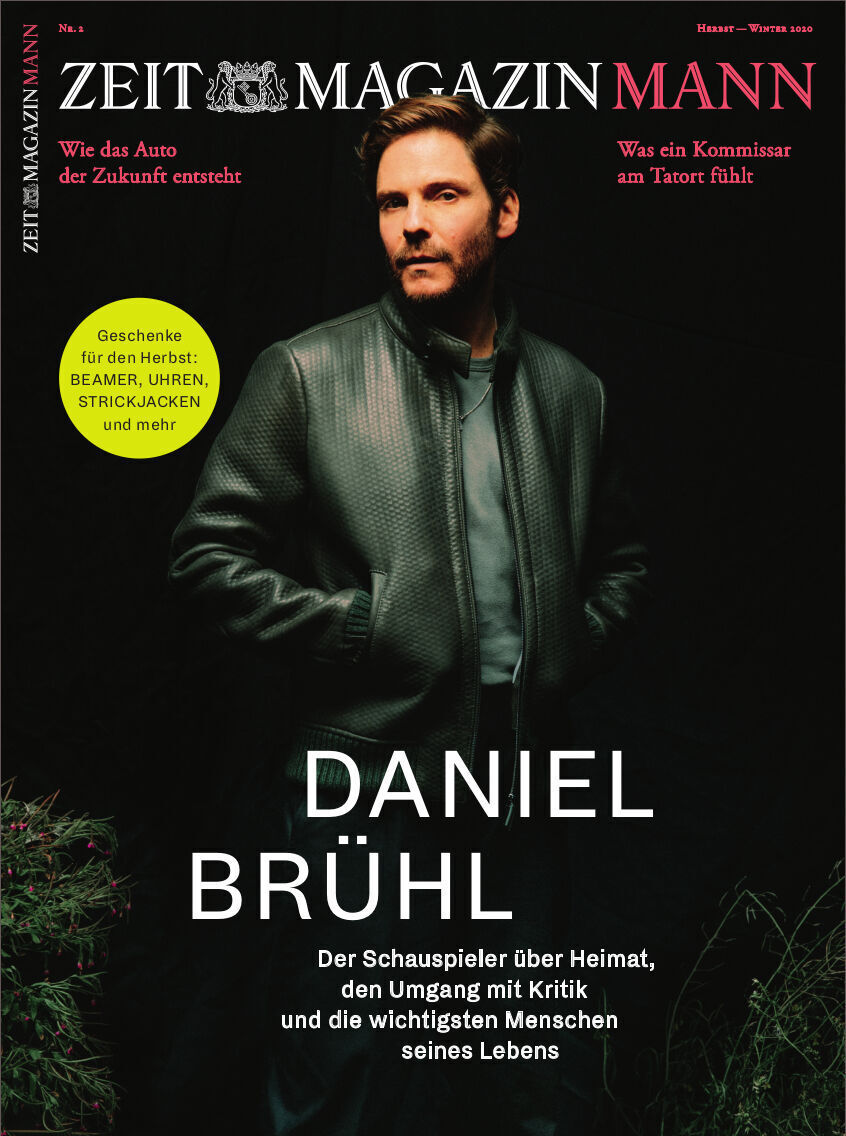Titelcover des ZEITmagazin MANN 2/20 mit Schauspieler Daniel Brühl im schwarzen Mantel. Der Hintergrund ist dunkel mit grünen und roten Schriftzügen.