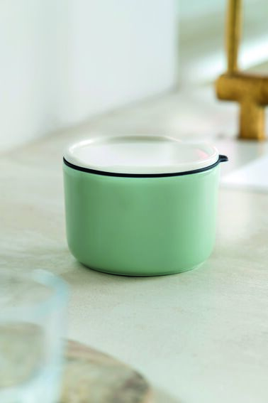 Eine grüne Lunchbox mit weißem Deckel, geeignet für die Aufbewahrung und den Transport von Speisen, ideal für Büro, Reisen und Picknicks.