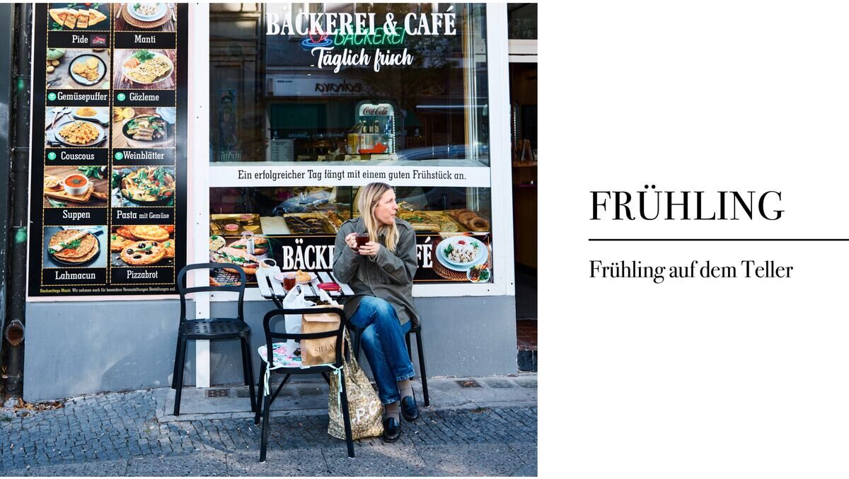 Eine Frau sitzt vor einer Bäckerei und genießt ihr Essen. Rechts im Bild steht der Titel 'FRÜHLING' mit dem Untertitel 'Frühling auf dem Teller'.