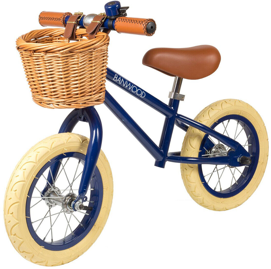 Ein Retro-Laufrad mit Körbchen, ideal für Kinder, das braune Griffe und Sitz sowie beige Reifen hat. Der Rahmen des Laufrads ist in einem tiefen Blau gehalten. Perfekt für Kinder, um Gleichgewicht und Fahrfähigkeiten zu erlernen.