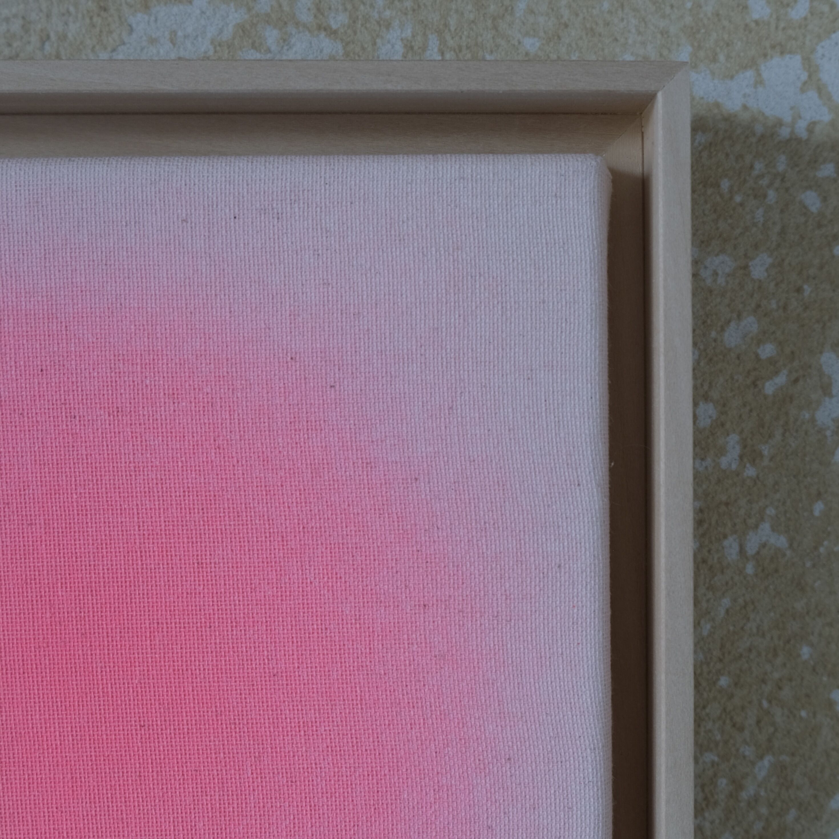 Detailaufnahme eines Kunstwerks der ZEIT-Sonderedition »Sorbet«, Apricot von Anastasia Benko. Sichtbar ist die obere linke Ecke eines quadratischen Bildes mit zarten, apricotfarbenen Farbverläufen auf ungebleichter Leinwand, gerahmt in naturfarbenem Lindenholz. Hintergrund leicht strukturiert.