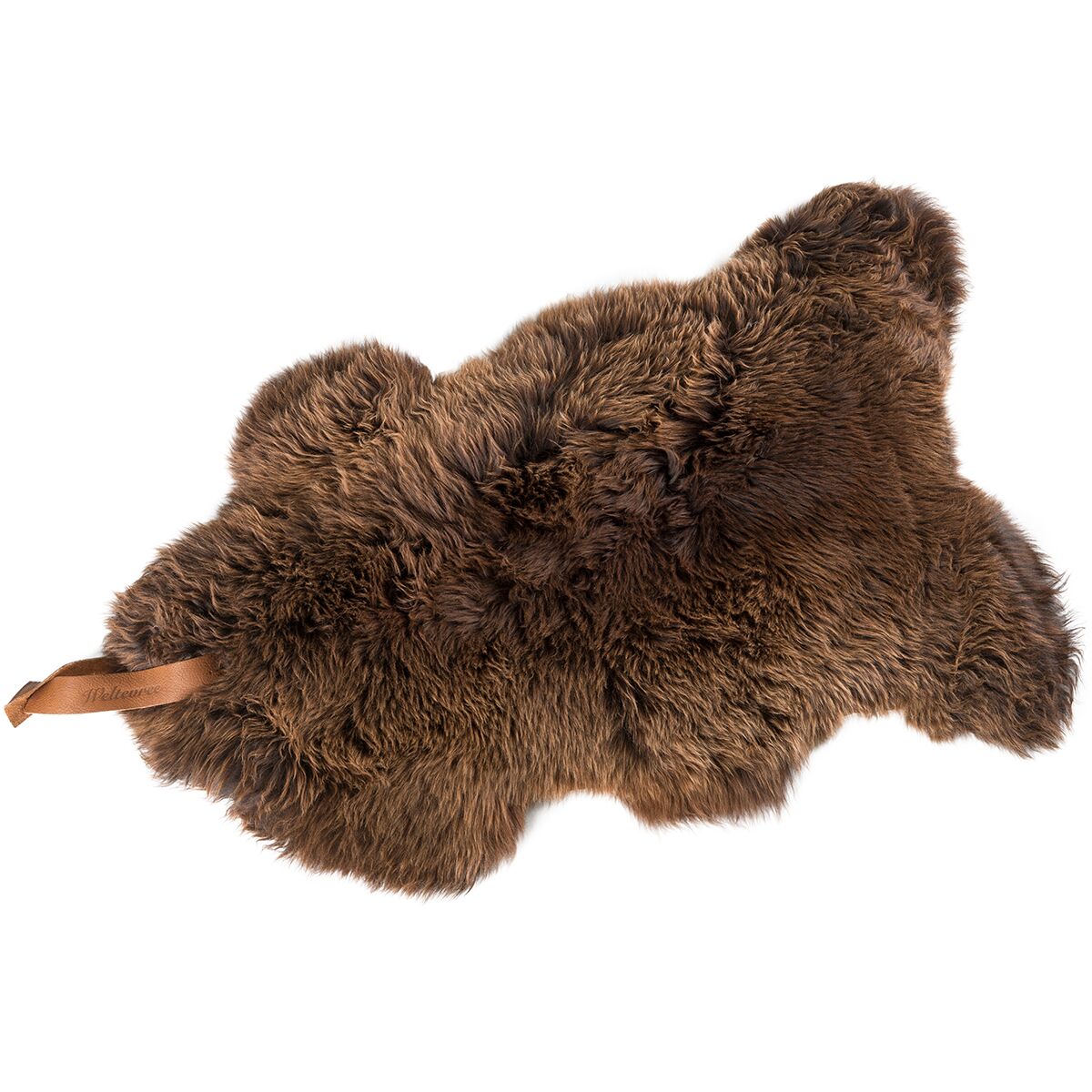 Braunes Schafsfell mit weicher, dichter Struktur und einer Lederschlaufe an der Seite. Das Fell liegt dekorativ und flach auf einer weißen Fläche, geeignet als Wohnaccessoire, Sitzauflage oder Teppich.
