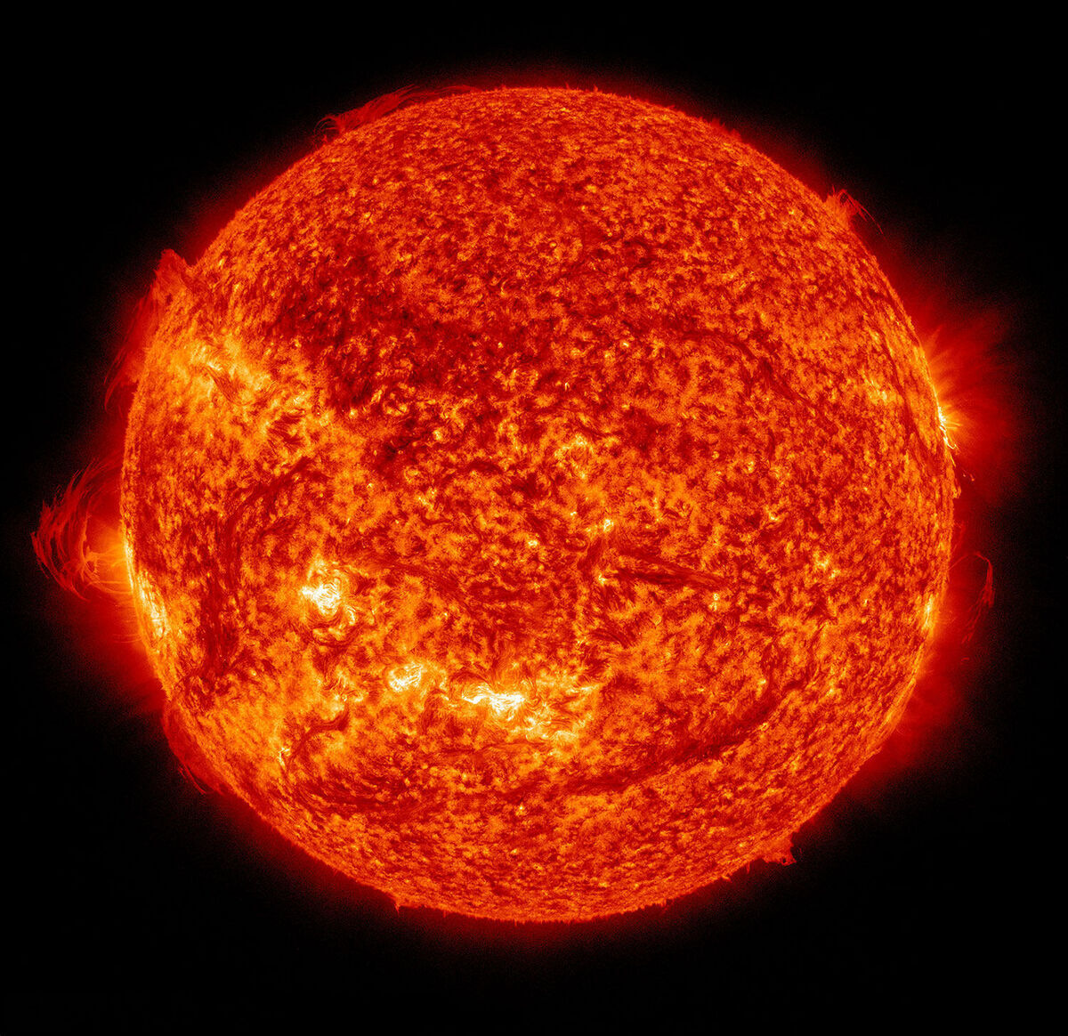 Ein farbenprächtiges Bild der Sonne, aufgenommen von der NASA im Jahr 2017. Die Sonne strahlt intensiv in Orange und Rot, Details der Sonnenoberfläche und Sonnenaktivität sind sichtbar, umgeben von einem schwarzen Hintergrund.