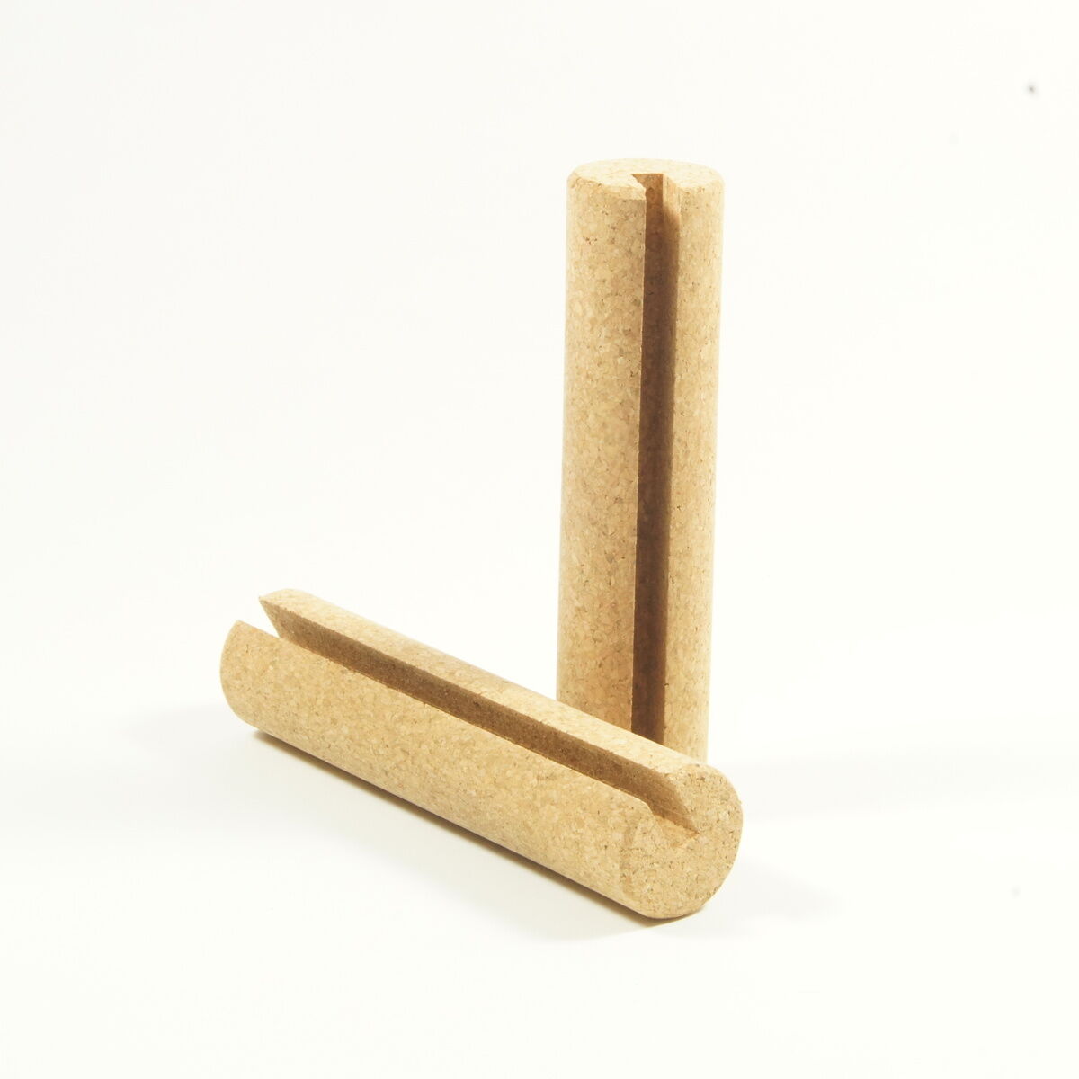 Zwei zylindrische Holzrollen stehen aufrecht auf einer glatten, hellen Oberfläche. Diese bilden Zubehör zu einem Balance Board, das Gleichgewichtstraining unterstützt.
