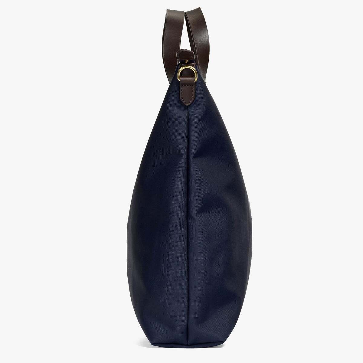 Ein stilvoller Shopper von MISMO in minimalistischem Design. Die Tasche ist aus blauem Stoff gefertigt und hat braune Ledergriffe. Perfekt für den täglichen Gebrauch oder als elegantes Accessoire.