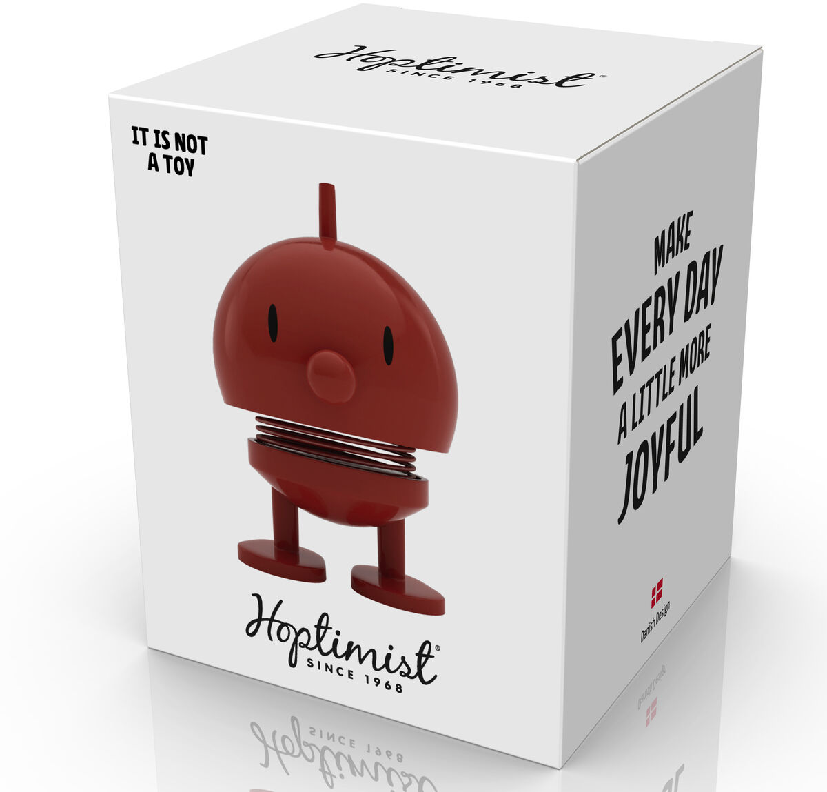 Weiße Produktverpackung der Hoptimist Bumble Maroon Figur mit großem Bild der dunkelroten, runden Federfigur aus ABS und Stahl. Aufdrucke: 'Make every day a little more joyful' sowie Hoptimist-Logo. Der Karton wirkt hochwertig und modern gestaltet.