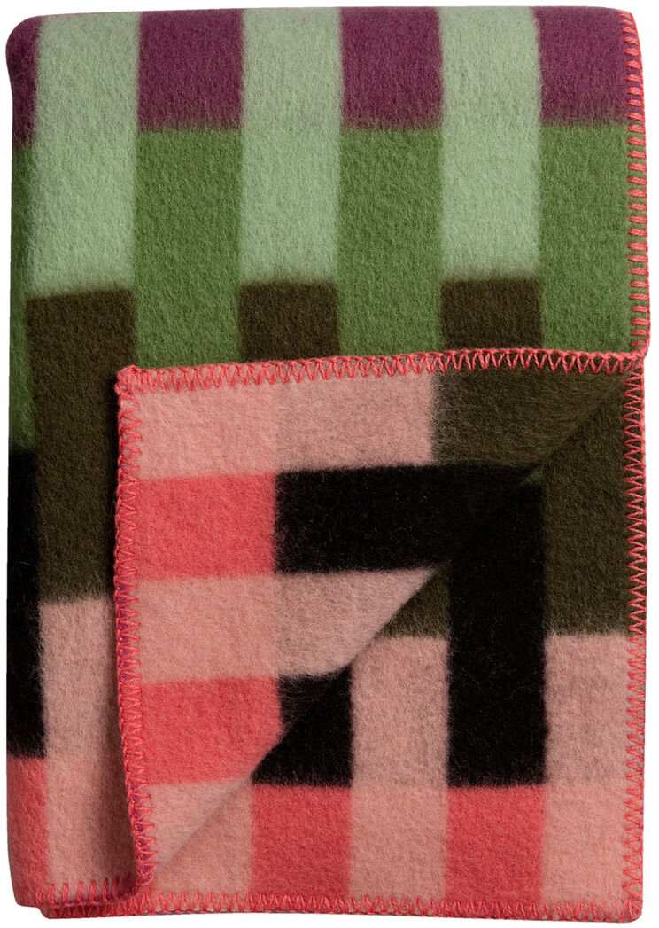 Eine Lammwolldecke mit einem geometrischen Quadratmuster in Grüntönen, Rosatönen, Schwarz, Lila und Orange. Ideal für das Sofa oder Wohnzimmer, um Gemütlichkeit und Wärme zu verbreiten.