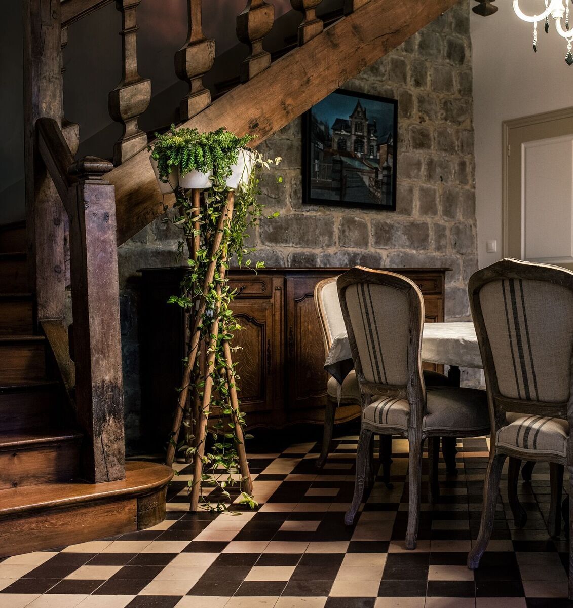 Hochgarten Produkt in einem gemütlichen, rustikalen Esszimmer mit hölzerner Treppe im Hintergrund, ein paar Pflanzen und Gemälde an der Wand, alles beleuchtet durch ein Kerzenleuchter.