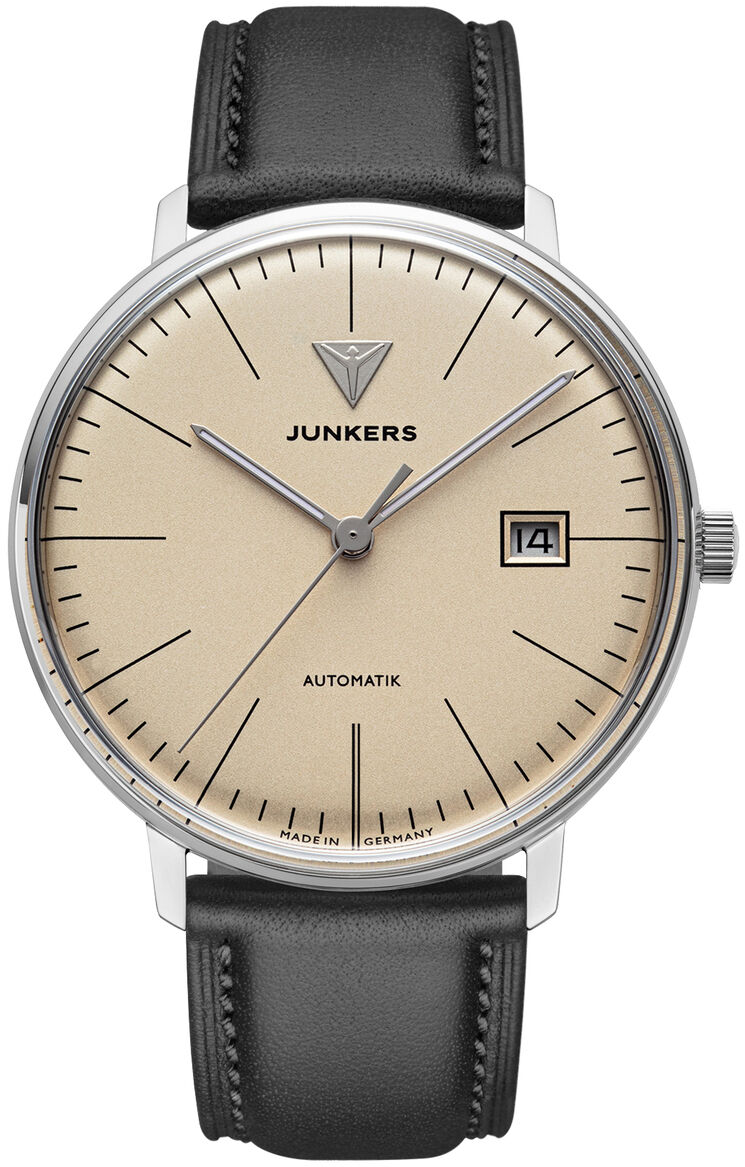 Die ZEIT-Sonderedition Uhr "Bauhaus Automatik" von Junkers Uhren zeigt ein beiges Zifferblatt mit schwarzen Indizes und Zeigern, Datumsanzeige bei drei Uhr, poliertes Edelstahlgehäuse und schwarzes Lederarmband. Der Stil ist minimalistisch und elegant.