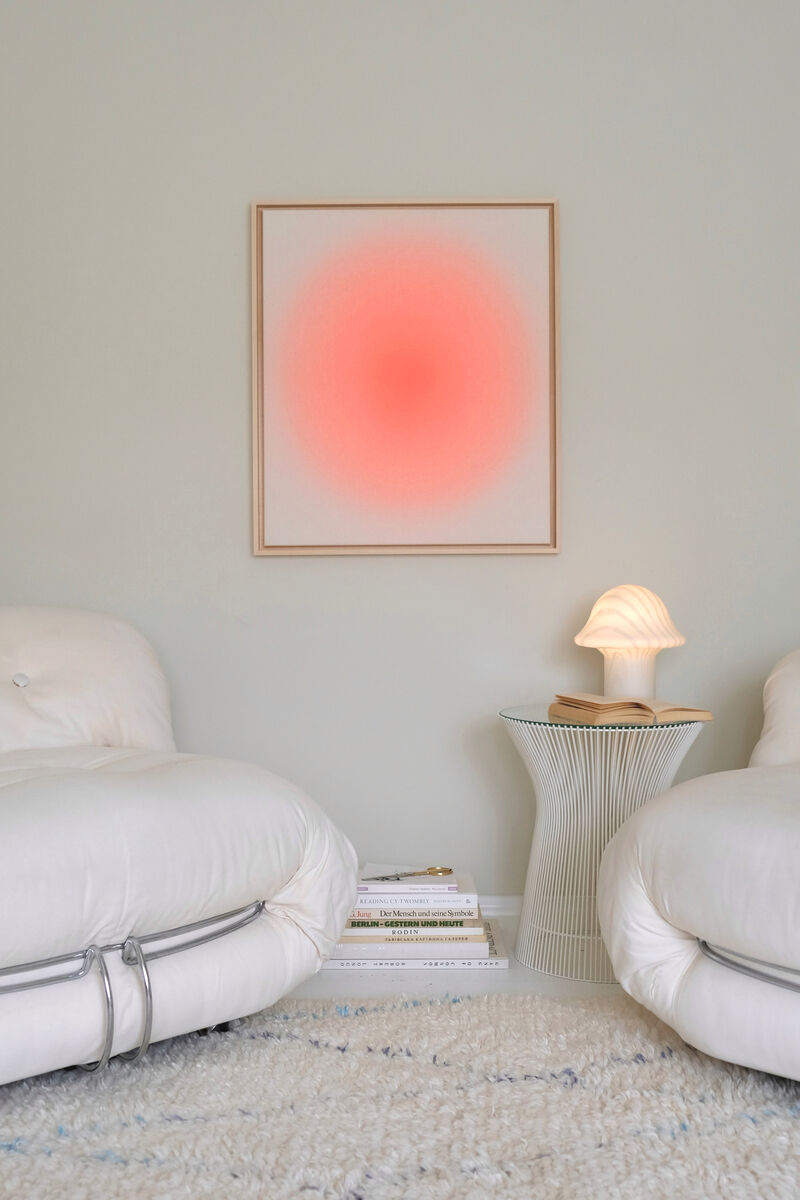 ZEIT-Sonderedition Sorbet »Apricot« (69x59cm). Gerahmtes Kunstwerk mit apricotfarbenem Farbverlauf in minimalistischer Inneneinrichtung. Das Bild hängt an einer grauen Wand zwischen zwei beigen Sesseln, neben denen ein kleiner Tisch mit Lampe steht.