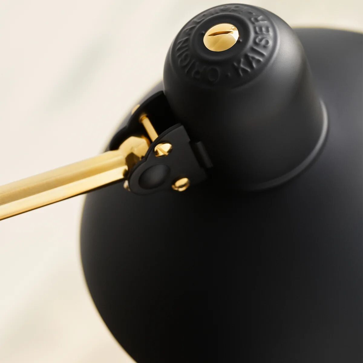 Detailaufnahme des mattschwarzen Lampenschirms der Stehlampe »KAISER IDELL« von Fritz Hansen. Zu sehen sind das charakteristische Drehgelenk aus Messing, das geprägte Logo „ORIGINAL KAISER-Idell“ sowie die präzise, hochwertige Verarbeitung im Bauhaus-Stil.