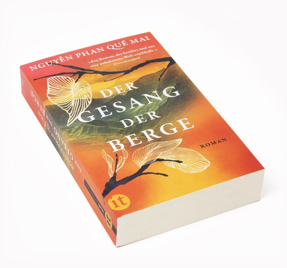 Abbildung des Buches 'Der Gesang der Berge' von Nguyễn Phan Quế Mai. Das Cover zeigt gelbe und orangefarbene Farbverläufe mit weißen Blüten und einem stilisierten Berg im Hintergrund. Der Titel und der Name der Autorin sind in weißen Buchstaben angegeben.