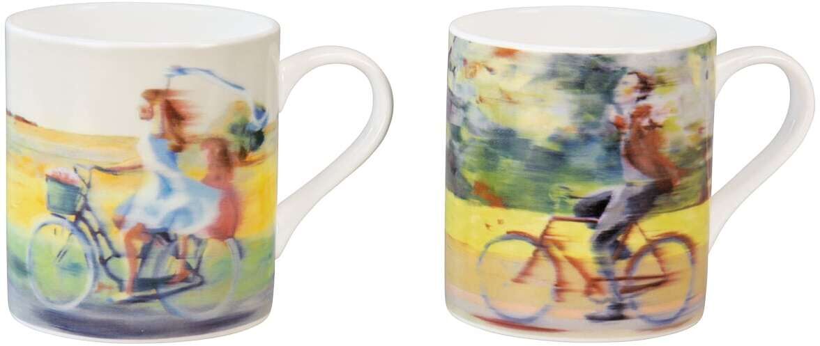 Zwei Becher im Set mit dem Titel „Gemeinsam unterwegs“ von Anja Struck. Die Becher zeigen Illustrationen eines Paares, das Fahrradtouren in einer malerischen Landschaft genießt.