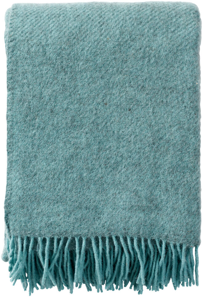 Eine flauschige, grün-blaue Woll-Decke mit Fransen, ideal für gemütliche Winterabende und dekorative Zwecke im Wohnzimmer.