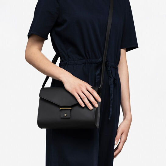 Frau trägt eine schwarze Leder-Schultertasche der ZEIT-Sonderedition »DIE ZEIT 3«.