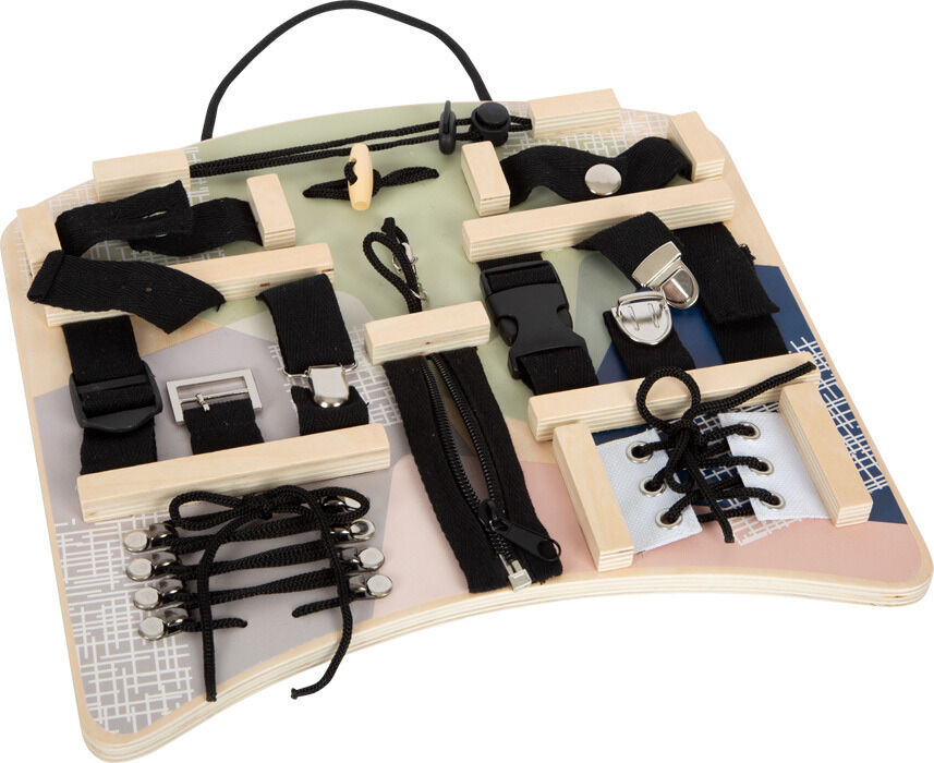 Ein Motorikbrett mit verschiedenen Befestigungen und Verschlüssen, darunter Schnallen, Reißverschlüsse und Schnürsenkel. Das Brett besteht aus Holz und enthält Elemente in Beige, Schwarz, Weiß, Grün und Rosa. Geeignet zur Förderung der Feinmotorik von Kindern.