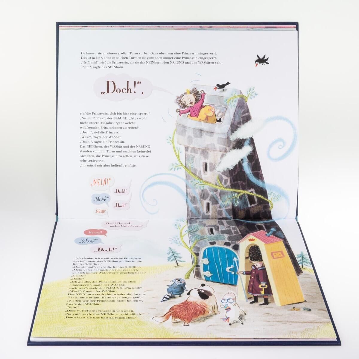 Ein offen liegendes Kinderbuch mit Illustrationen, das das Abenteuer des 'Das NEINhorn' zeigt. Das Bild zeigt einen illustrierten Turm mit verschiedenen Charakteren und helle, kindgerechte Farben.