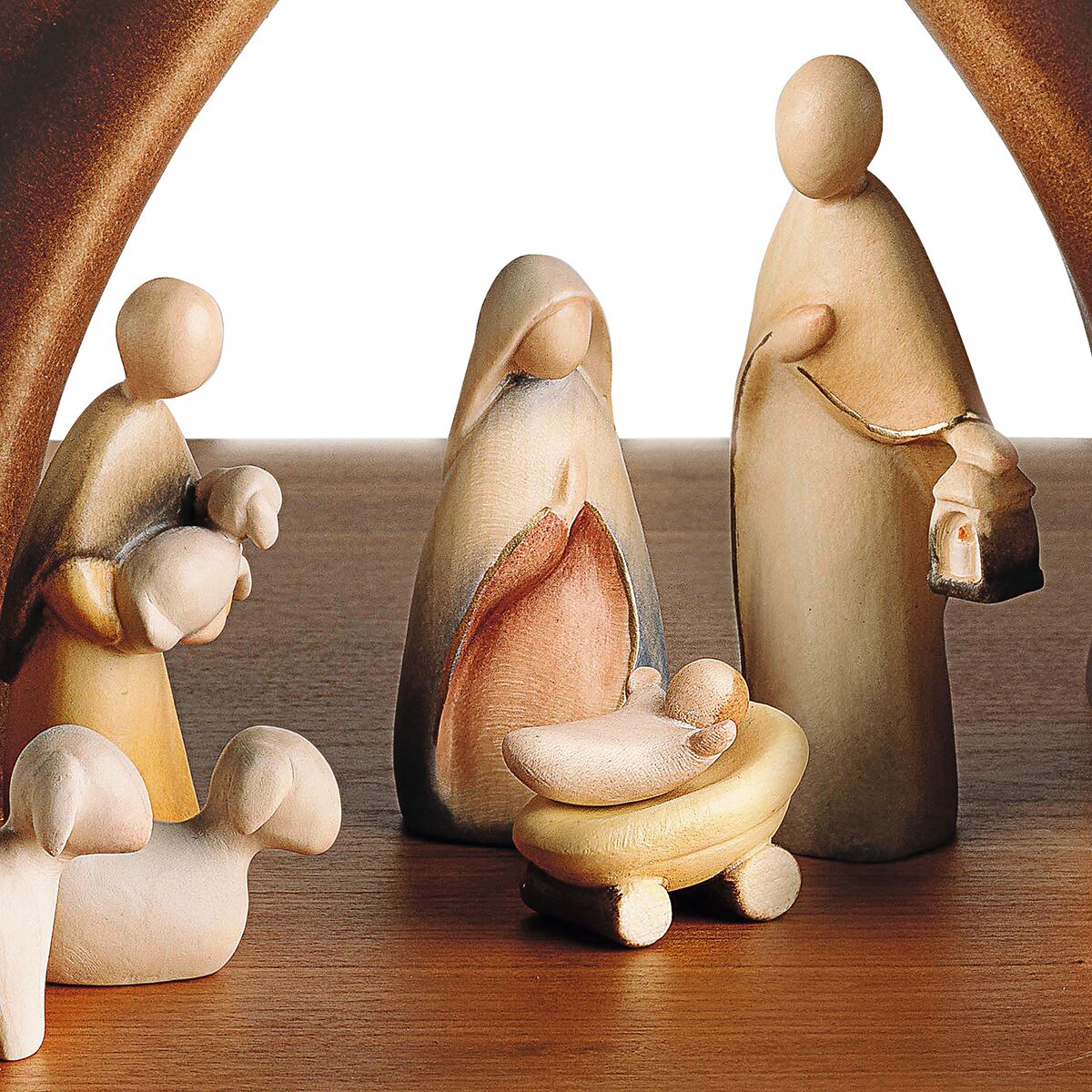 Holzgeschnitzte Weihnachtskrippe mit zwölf stilisierten Figuren, darunter Maria, Josef, das Jesuskind in der Krippe, ein Engel und weitere Figuren sowie Tiere, liebevoll arrangiert unter einem angedeuteten Holzbogen. Die Figuren sind in sanften Beige- und Brauntönen gehalten. Ideal als festliche Dekoration zur Weihnachtszeit für die Darstellung der Geburt Jesu.