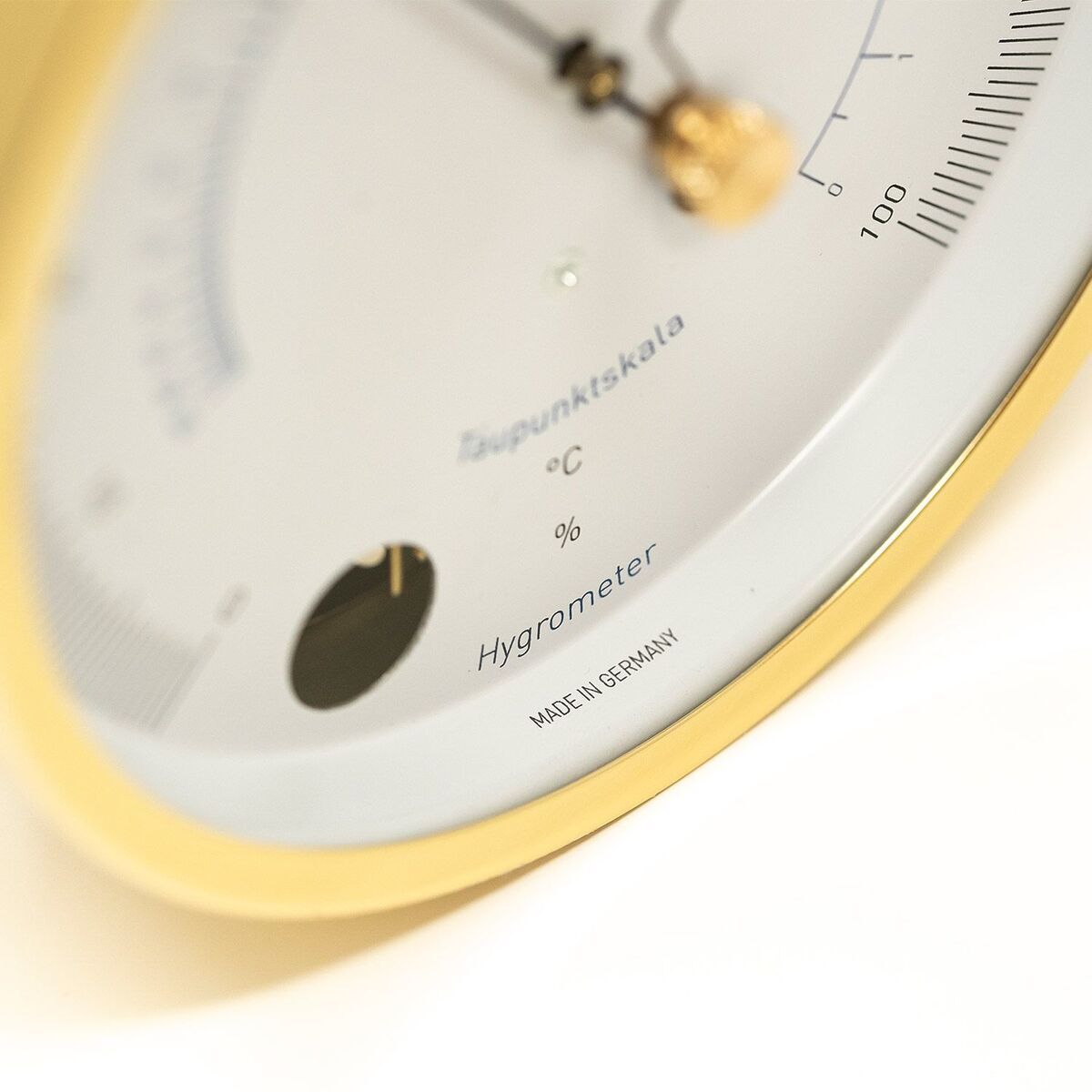Nahaufnahme eines analogen Haar-Hygrometers der Marke ZEIT-Sonderedition »POLAR«. Es verfügt über eine weiße Skala mit schwarzen Markierungen und goldfarbenen Elementen. Hergestellt in Deutschland.