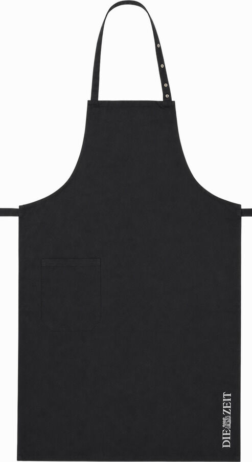 Schwarze Kochschürze aus 100% Baumwolle mit verstellbarem Nackenband, aufgesetzter Tasche und vertikalem weißen DIE ZEIT-Logo im unteren Bereich. Schlichtes, modernes Design, hochwertig verarbeitet. Perfekt für Hobbyköche und Kochliebhaber. Hintergrund weiß.