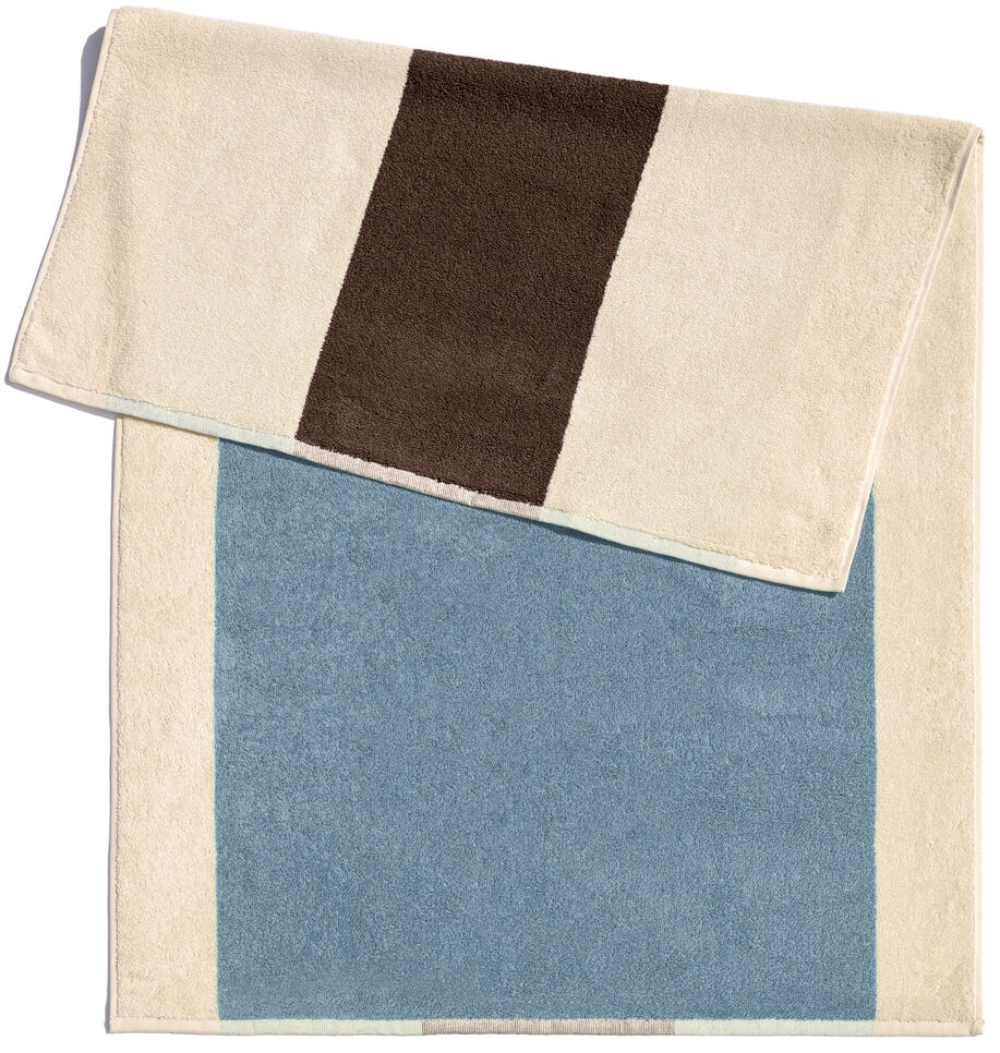 Eine rechteckige Badematte mit den Maßen 50 x 80 cm in den Farben Blau, Beige und Braun. Die Matte hat ein einfaches und modernes Design.