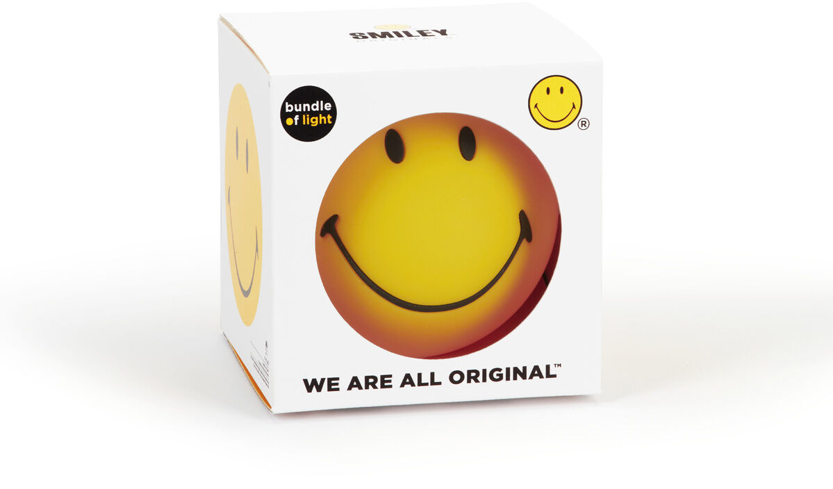 Ein Nachtlicht in Form eines lachenden Smileys, verpackt in einer weißen Box mit der Aufschrift 'WE ARE ALL ORIGINAL' und 'bundle of light'.