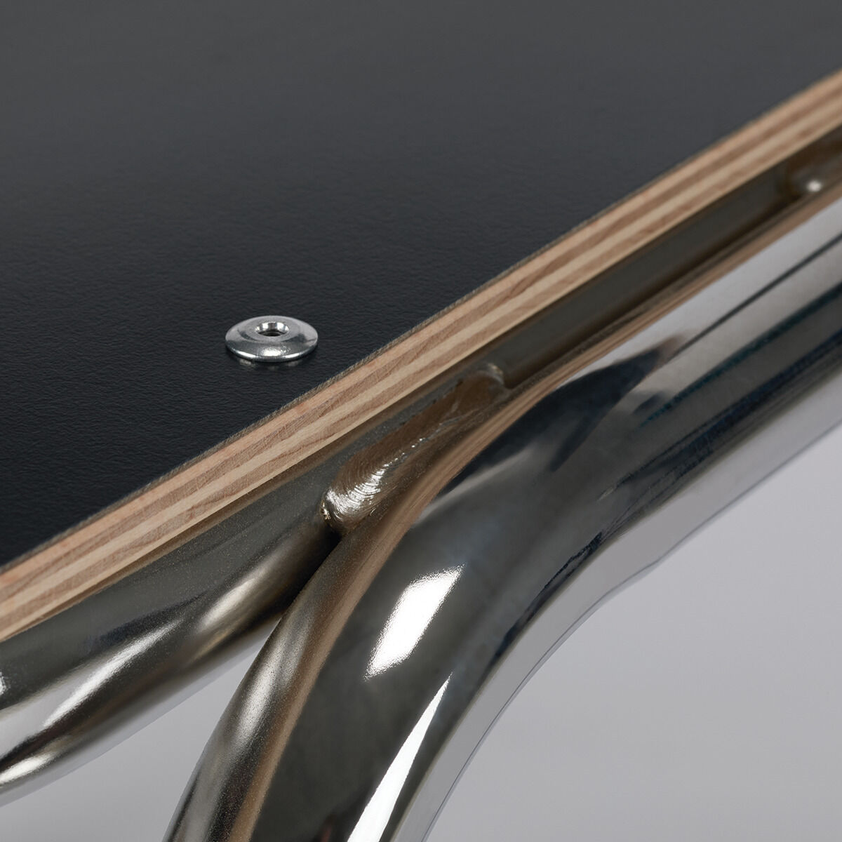 Nahaufnahme eines ZEIT-Sonderedition Stuhls »ZERO«. Sichtbarer Metallrahmen und eine Sitzfläche in Holzoptik mit modernen Designakzenten.