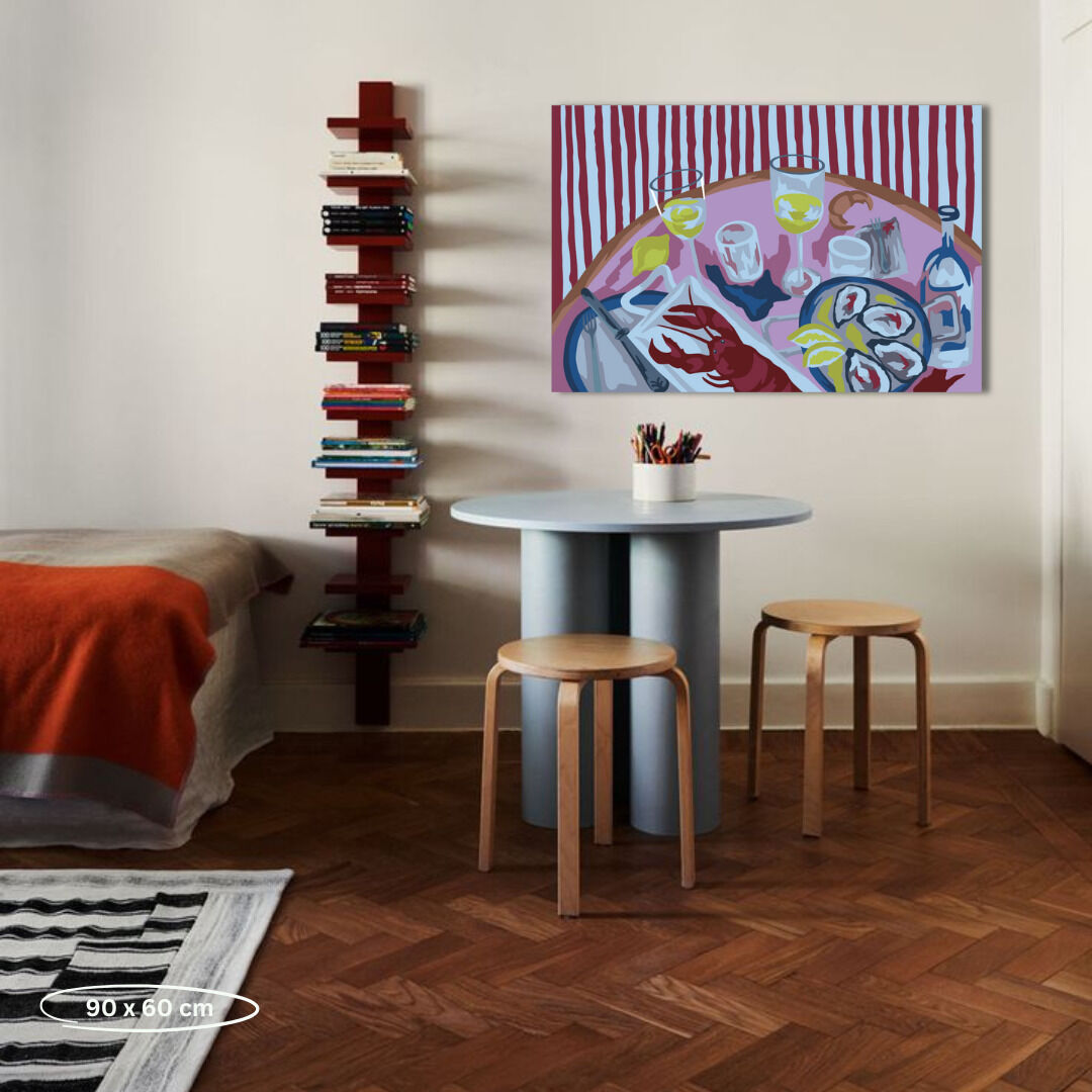 Ein modernes Interieur mit einem runden Tisch, zwei Hockern, einem Bücherregal und einem Gemälde an der Wand, das ein Malen-nach-Zahlen-Motiv von Austern und Gläsern mit Getränken zeigt