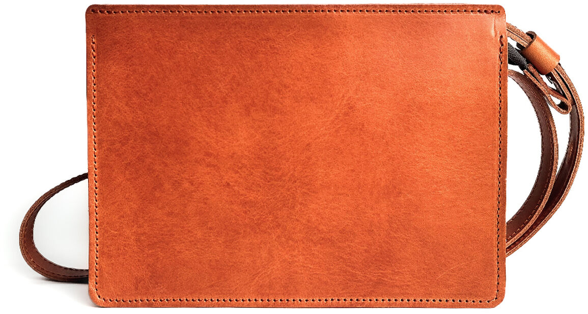 Eine rechteckige Umhängetasche aus glattem, cognacfarbenem Kernleder mit schlichtem, modernem Design und feinen Nähten. Die Tasche liegt auf weißem Hintergrund, der Schulterriemen ist seitlich sichtbar.