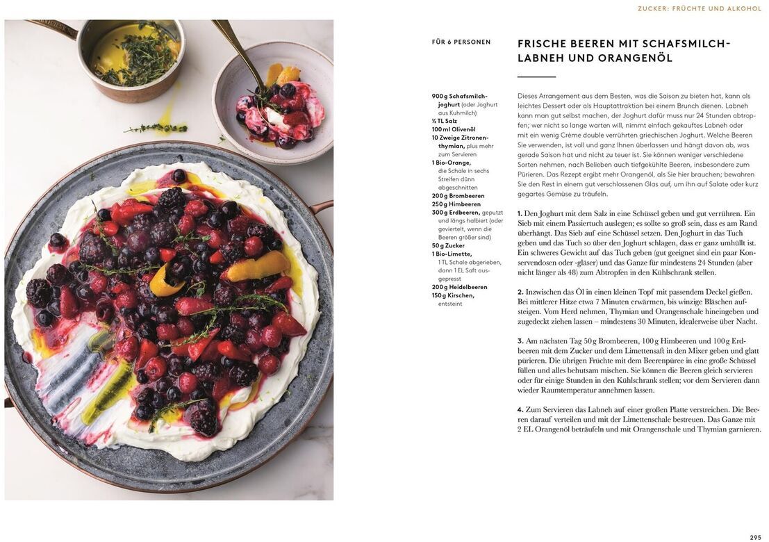 Ein aufgeschlagenes Kochbuch mit einem farbenfrohen Dessert aus frischen Beeren, Schafsmilch und Orangenöl auf einer Seite und einem Rezepttext auf der anderen Seite.