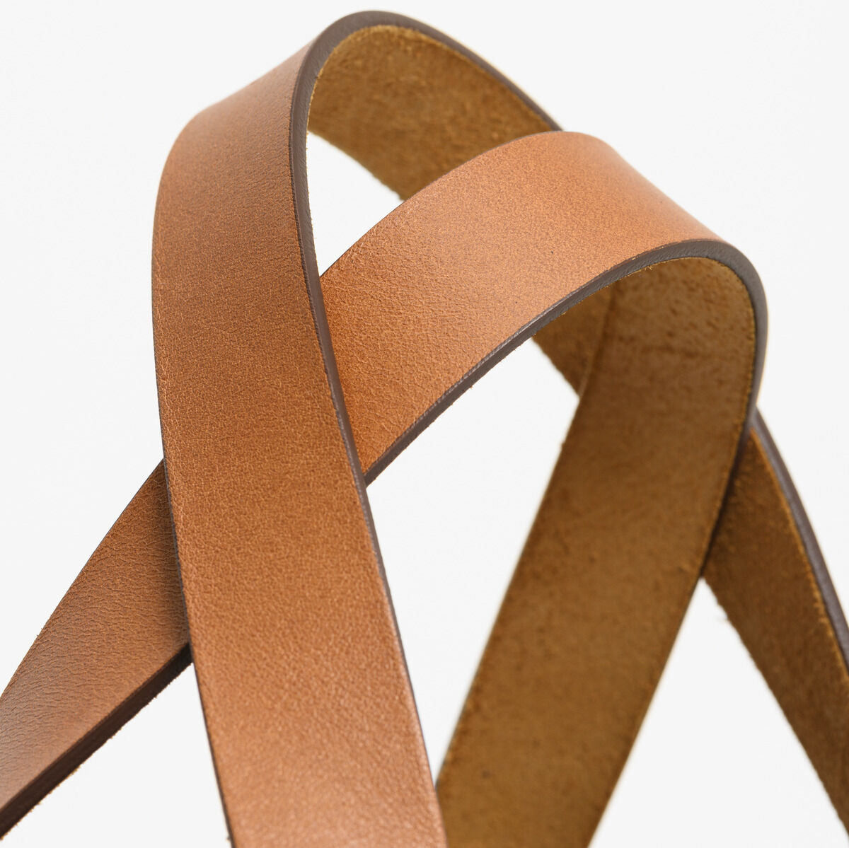 Nahaufnahme der Ledergriffe einer braunen Shopper-Tasche aus hochwertigem Leder.