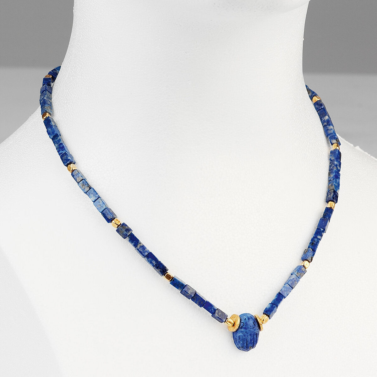 Elegante Halskette aus echter Lapislazuli mit goldenen Akzenten und Skarabäus-Anhänger, präsentiert auf einem weißen Hintergrund.