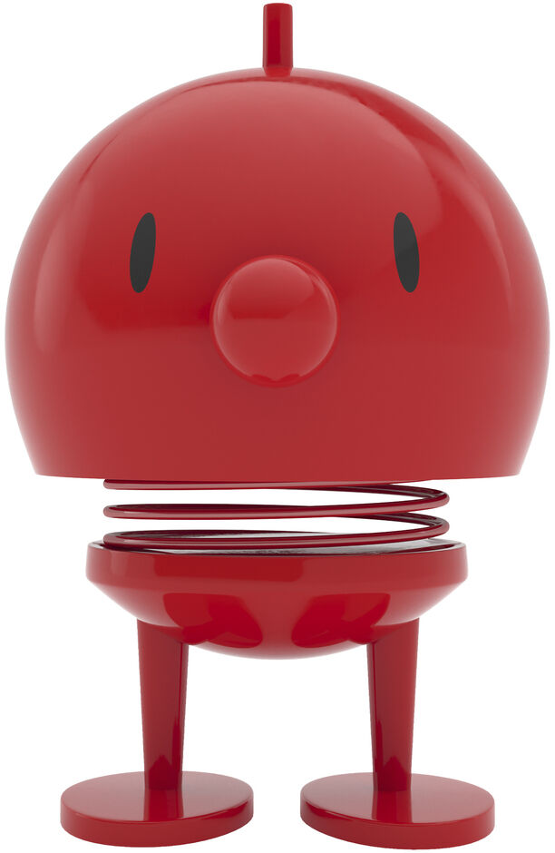 Rote Hoptimist Bumble Figur mit einer runden Form, zwei schwarzen Punkten als Augen und einer federnden Basis auf einem weißen Hintergrund. Das Design ist minimalistisch und verspielt.