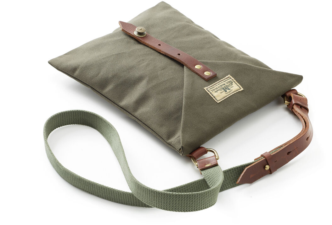 Eine Kartenhülle aus Segeltuch mit braunen Lederriemen, goldenem Etikett und grünem Trageriemen. Besonders geeignet für Outdoor-Aktivitäten wie Wandern oder Reisen.