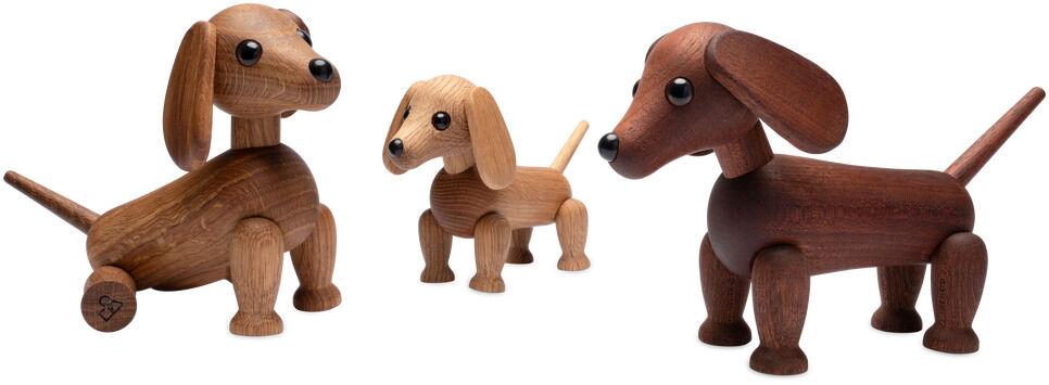 Drei unterschiedlich große, naturfarbene bis dunkelbraune Holzfiguren eines Dackels von Spring Copenhagen stehen nebeneinander auf weißem Hintergrund. Die Figuren wirken freundlich und detailreich mit markanten langen Ohren und schwarzer Nasenspitze.