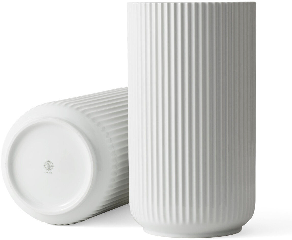 Abgebildet ist die Vase »Lyngby« in weiß. Sie ist eine hohe, runde Keramikvase mit vertikalen Rillen. Eine steht aufrecht, die andere liegt seitlich.