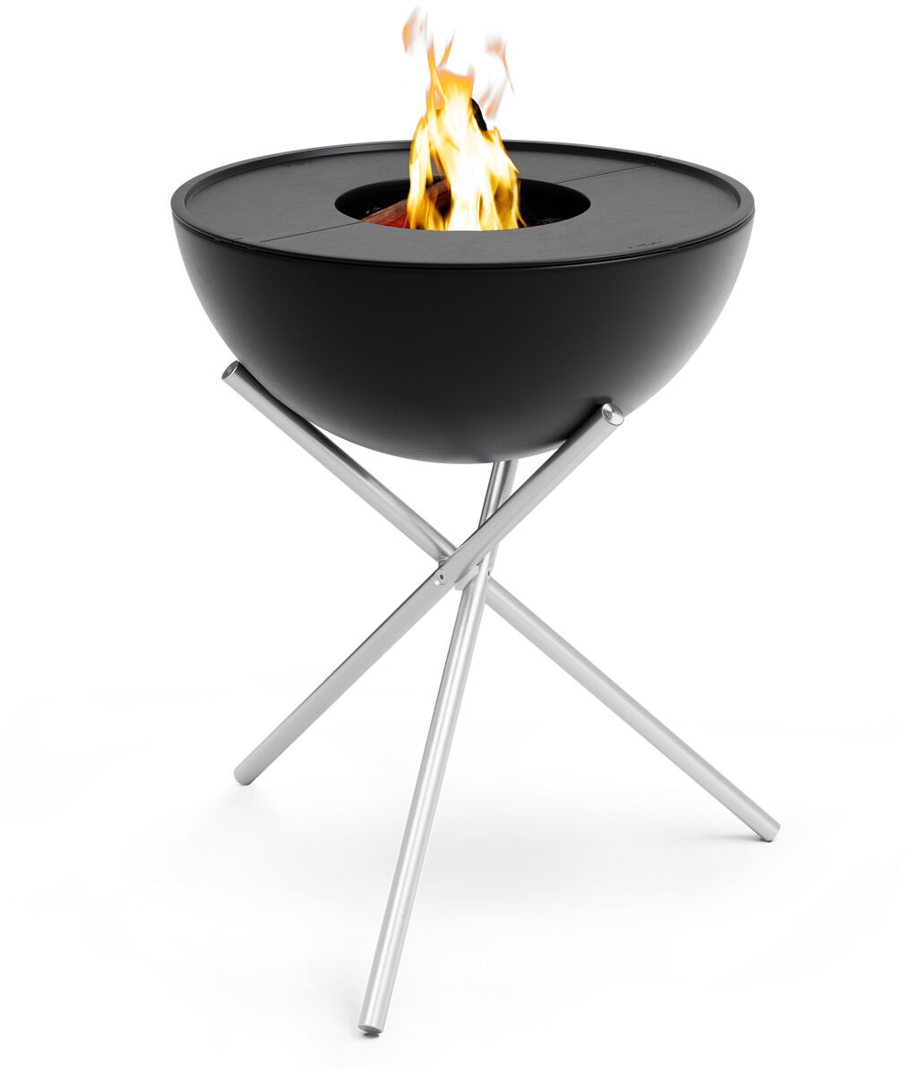 Schwarzer Plancha-Grill 'BOWL 57' auf silbernem Ständer, mit brennendem Feuer in der Mitte.