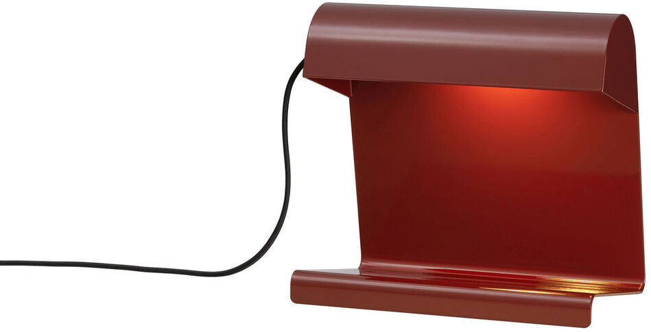 Eine modern gestaltete Tischlampe namens 'Lampe de Bureau' in Rot mit einem schwarzen Stromkabel. Die Lampe strahlt ein warmes gelbes Licht aus.