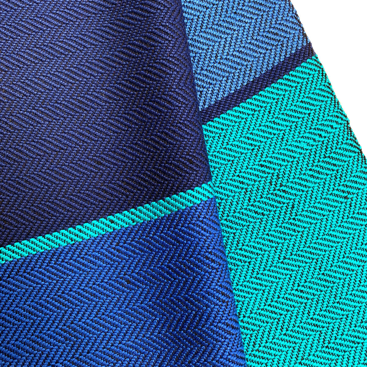 Ein eleganter Seidenschal in Blau und Türkis mit feinen Mustern und hochwertiger Verarbeitung. Ideal als stilvolles Modeaccessoire.