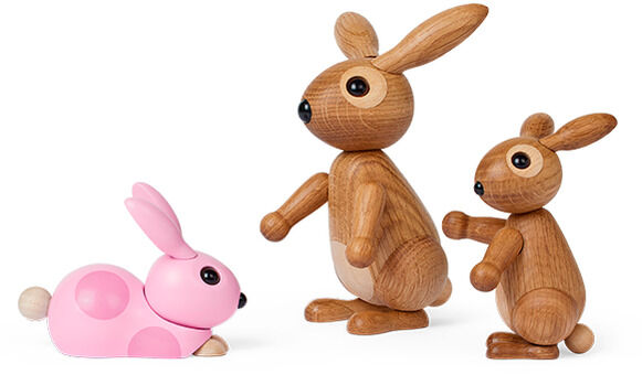 Drei hölzerne Hasen-Dekorationsfiguren auf weißem Hintergrund. Zwei braune stehende Hasen und ein rosa liegender Hase, ideal zur Frühlings- und Osterdekoration geeignet.