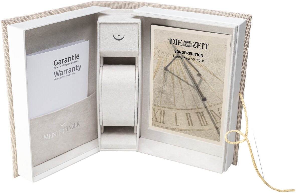 Hochwertige, buchförmige Verpackung der ZEIT-Sonderedition Automatikuhr »N°03« von MeisterSinger. Links Garantiezertifikat, mittig Uhrenhalterung, rechts stilvolles ZEIT-Design mit Sonnenuhr und goldener Schleife. Edler, minimalistischer Look für Uhrenliebhaber.