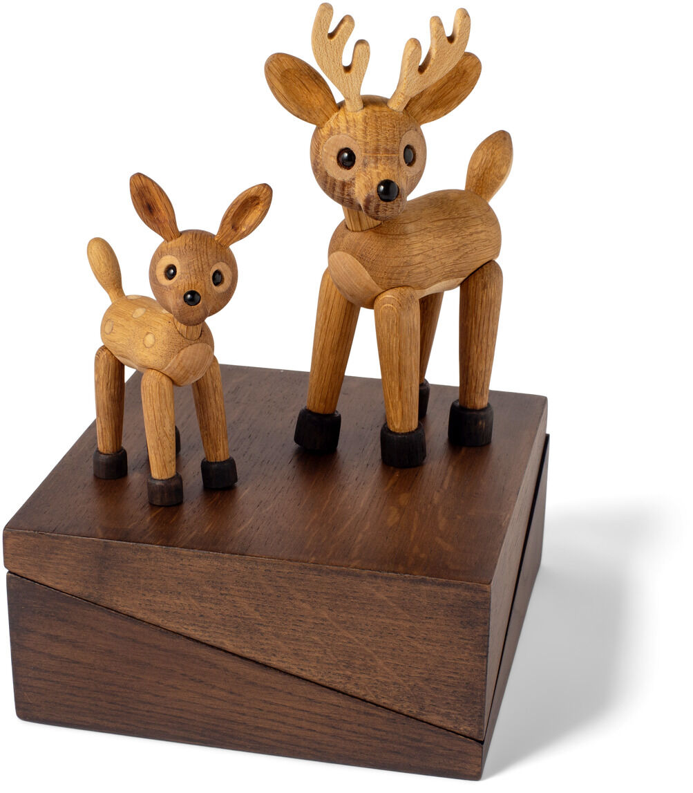 Zwei Holzfiguren in Form eines Rehs und eines Elchs stehen auf einem dunklen rechteckigen Holzsockel. Beide Tiere sind aus glattem, naturbelassenem Holz gefertigt und zeigen freundliche Gesichter. Die Darstellung zeichnet sich durch minimalistisches, skandinavisches Design aus.