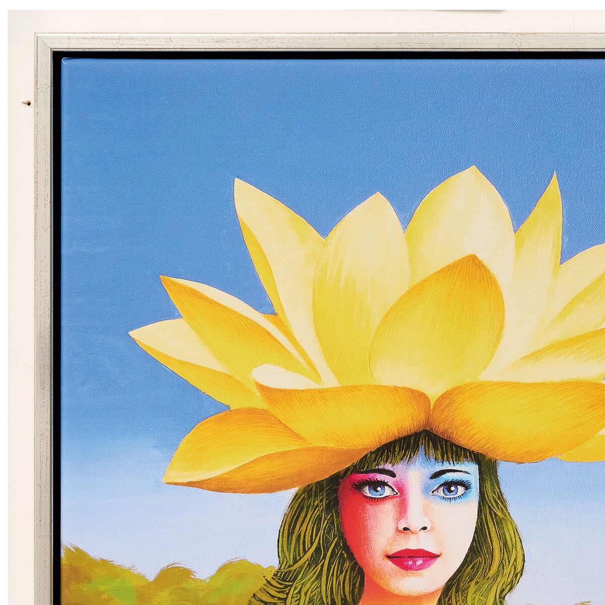 Das Kunstwerk zeigt eine fotorealistische weibliche Porträtzeichnung vor einem leuchtend blauen Himmel, deren Kopf aus einer großen, gelben Seerosenblüte herausragt. Die Silberrahnung umgibt das farbintensive Bild. Im Hintergrund sind zarte Landschaftskonturen zu sehen.