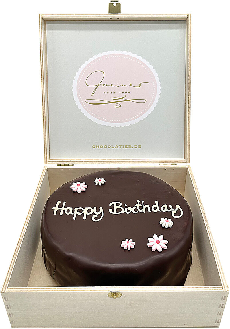 Eine luxuriöse Sachertorte in einer eleganten Holzkiste, dekoriert mit der Aufschrift 'Happy Birthday' und kleinen Blumen aus Zuckerguss.