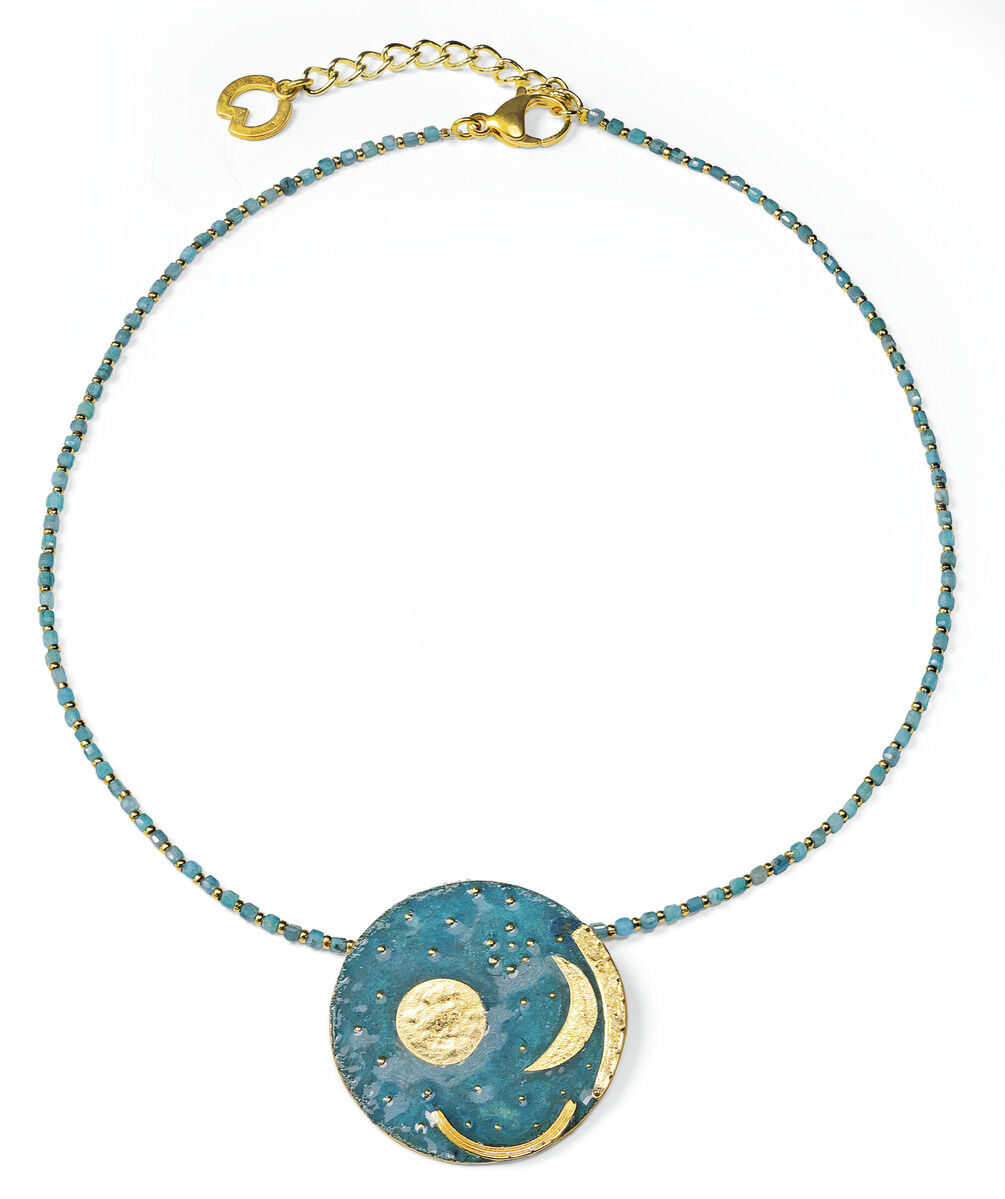 Auf dem Bild ist das Collier 'Himmelsscheibe von Nebra' von Petra Waszak zu sehen. Das Collier besteht aus runden, glatten Perlen in Grün- und Türkistönen und goldfarbenen Elementen. Im Zentrum befindet sich ein goldfarbener Anhänger, der die berühmte Himmelsscheibe detailreich nachempfindet.