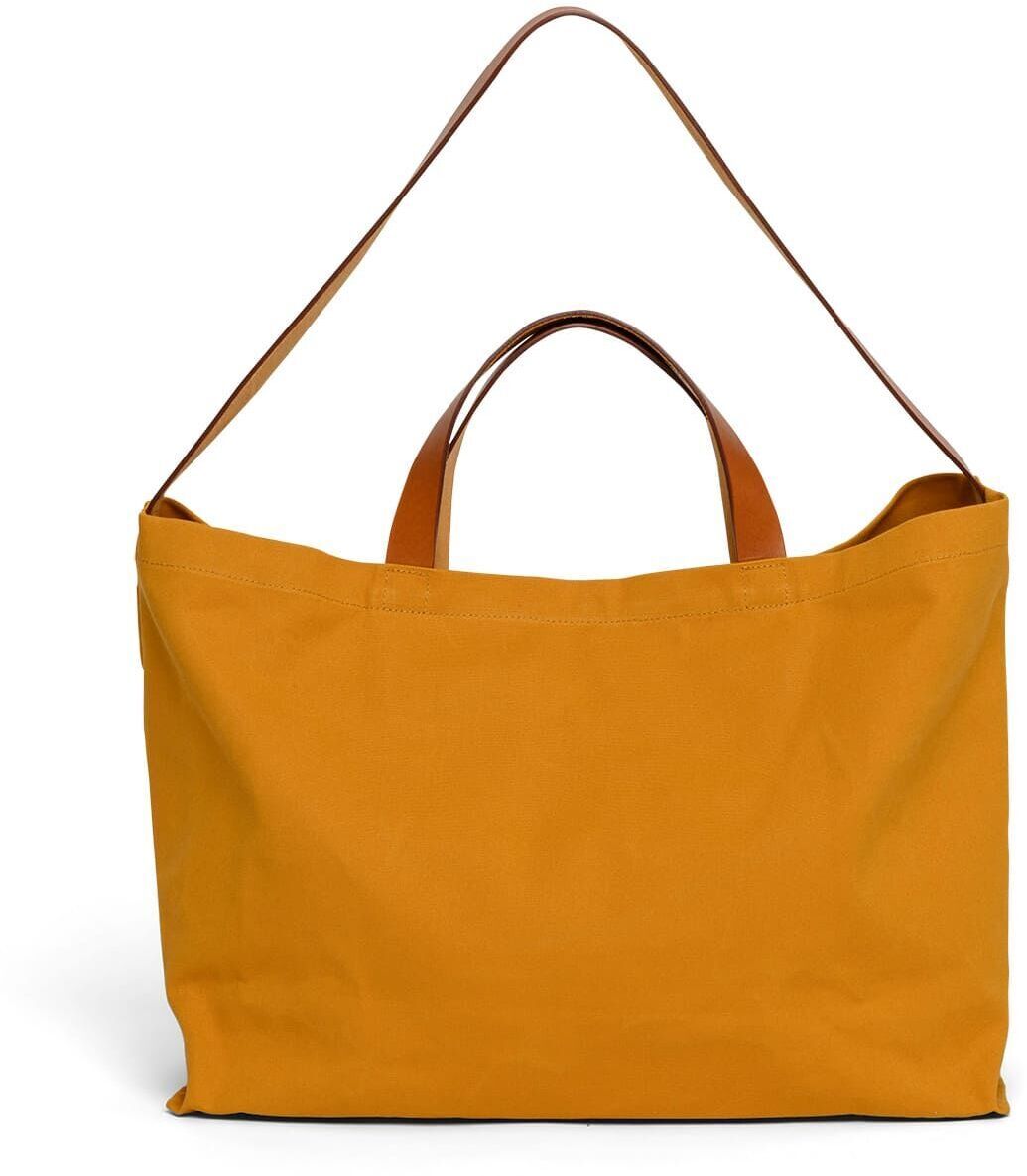 Die Jubiläums-Markttasche ist eine große, gelbe Tasche aus Baumwolle mit braunen Griffen, ideal für den täglichen Einkauf und andere Aktivitäten.