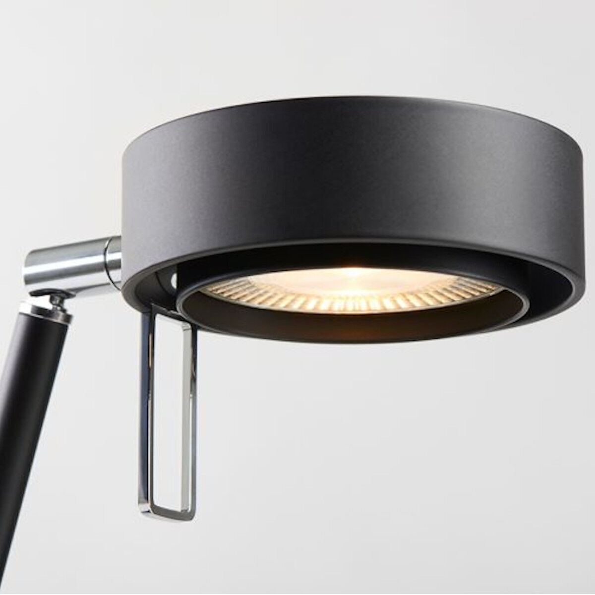 Die Tischleuchte »Pure« ist eine moderne, schwarze Lampe mit einem minimalistischen Design. Sie besteht aus Metall und hat einen runden Lampenschirm mit integriertem Licht. Geeignet für den Einsatz im Büro oder im Wohnzimmer.