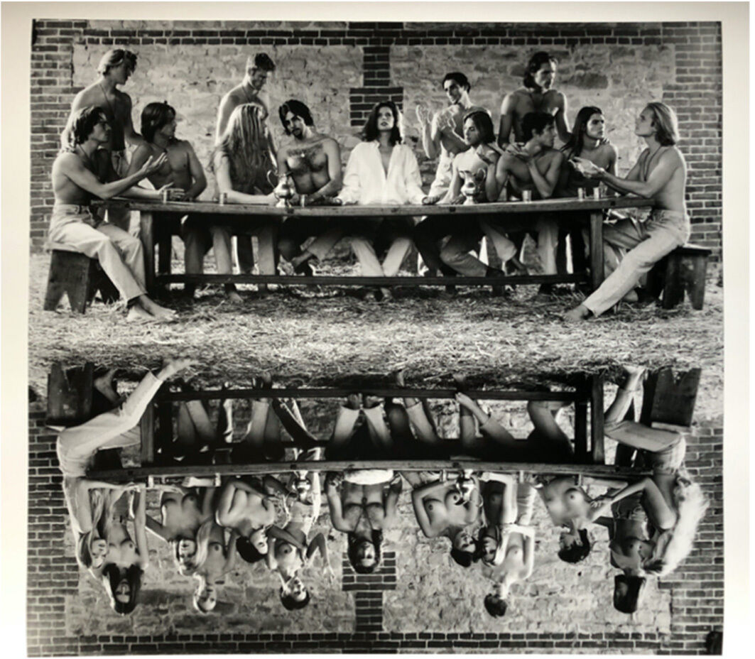 Schwarz-weiß Fotografie von Wackerbarth aus dem Jahr 1993 mit dem Titel 'Paradise Now: Abendmahl – Geschlechterspiegelung'. Die Szene zeigt eine Gruppe von Menschen an einem langen Tisch, wobei deren Spiegelbild darunter widergespiegelt wird. Die Anordnung der Personen ist symbolisch und erinnert an das historische Bild des letzten Abendmahls.